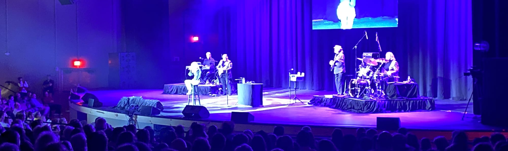 signer on stage in chair washed out by the lights Los Angeles